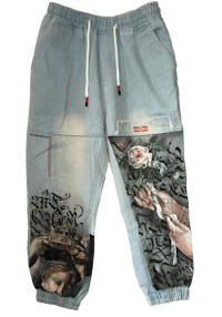 a pair of denim joggers with a painting on them