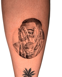 a tattoo of a man covering his face with his hands